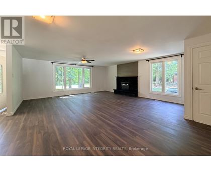 A spacious room with wooden flooring and a ceiling fan.