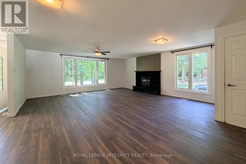 A spacious room with wooden flooring and a ceiling fan.