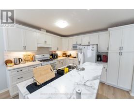 A kitchen with white cabinets and a marble countertop.