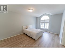 A bedroom with a bed, wooden floors, and a window.