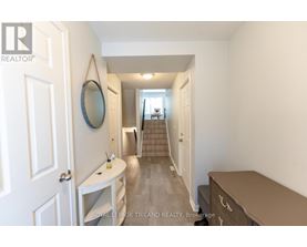 A hallway with a mirror and a staircase.