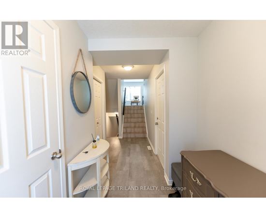 A hallway with a mirror and a staircase.