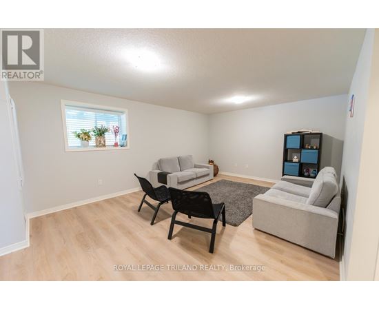 A living room with a grey couch, a black chair and a TV.