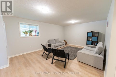 A living room with a grey couch, a black chair and a TV.