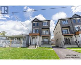 A row of modern townhouses with a grassy front yard.