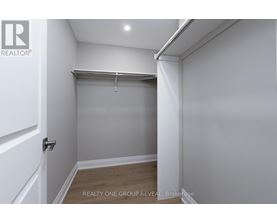 A white bedroom with a sliding door and a wooden floor.