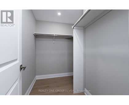 A white bedroom with a sliding door and a wooden floor.