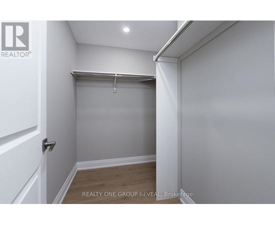 A white bedroom with a sliding door and a wooden floor.