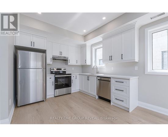 A modern kitchen with white cabinets and stainless steel appliances.