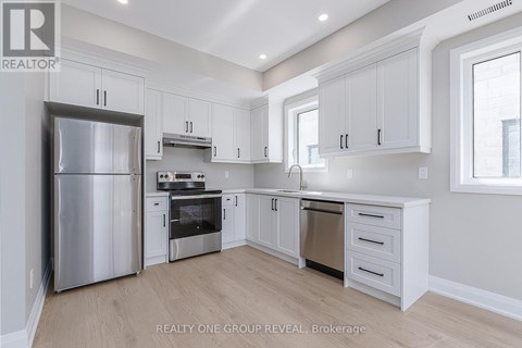 A modern kitchen with white cabinets and stainless steel appliances.