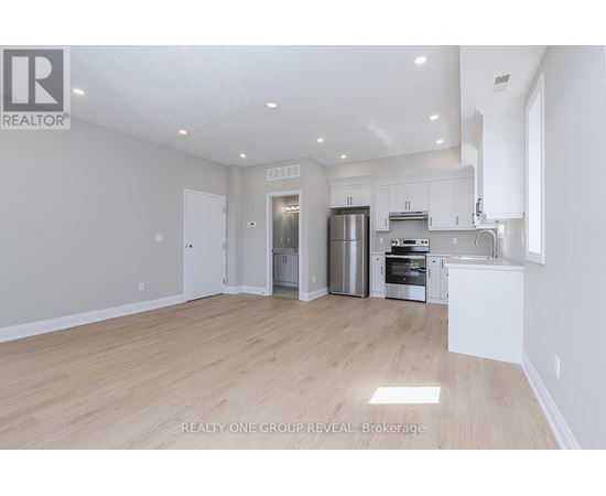 A spacious kitchen with stainless steel appliances and white cabinetry.