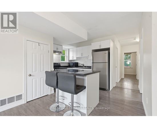 A kitchen with white cabinets and a black countertop.