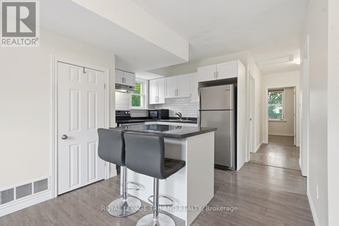 A kitchen with white cabinets and a black countertop.