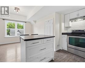 A kitchen with white cabinets and a black countertop.