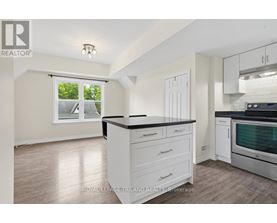A kitchen with white cabinets and a black countertop.