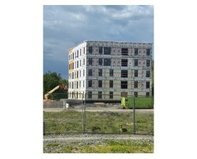 A large building with many windows is under construction.