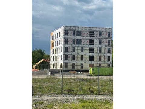A large building with many windows is under construction.