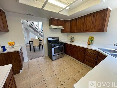 A kitchen with wooden cabinets and a tiled floor.