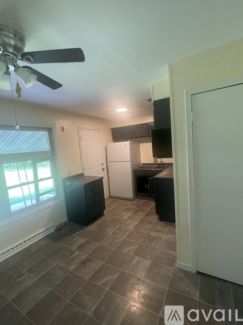 A kitchen area with tile flooring and a ceiling fan.