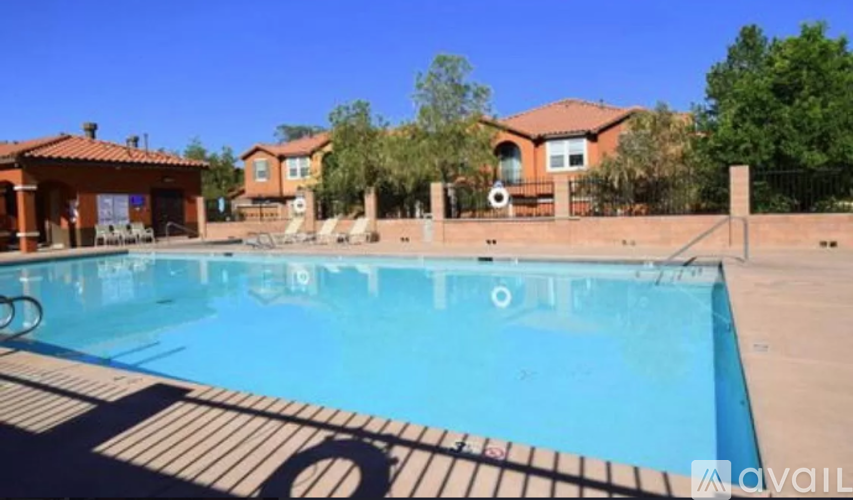 A pool in a backyard with a house in the background.