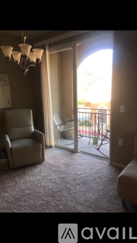 A living room with a chair and a chandelier.