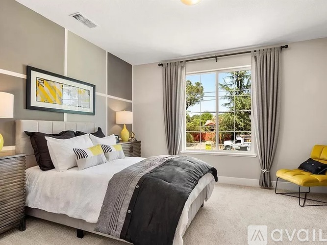 A bedroom with a large bed and a window overlooking a street.