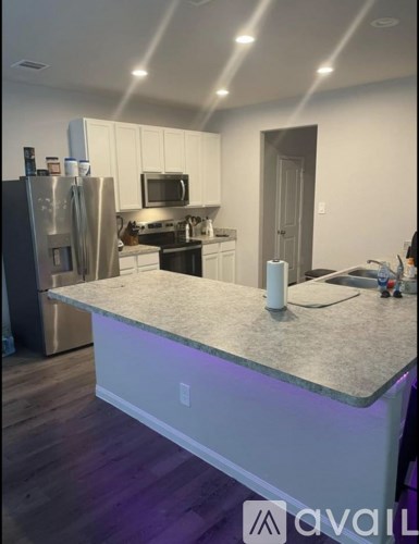 A kitchen with a refrigerator, microwave, and oven.