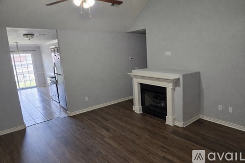 A living room with a fireplace and wood flooring.