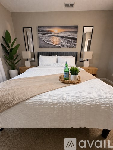 A bedroom with a large bed and a painting on the wall.