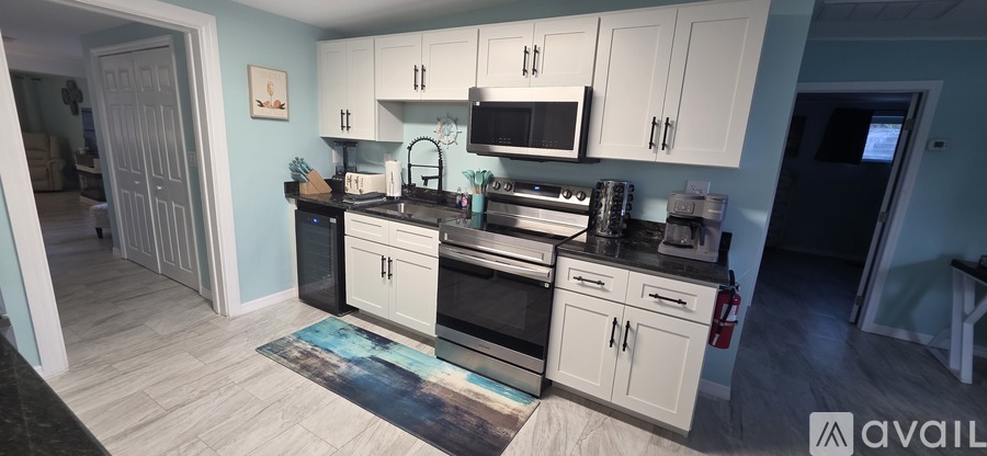 A kitchen with white cabinets and a blue accent wall.