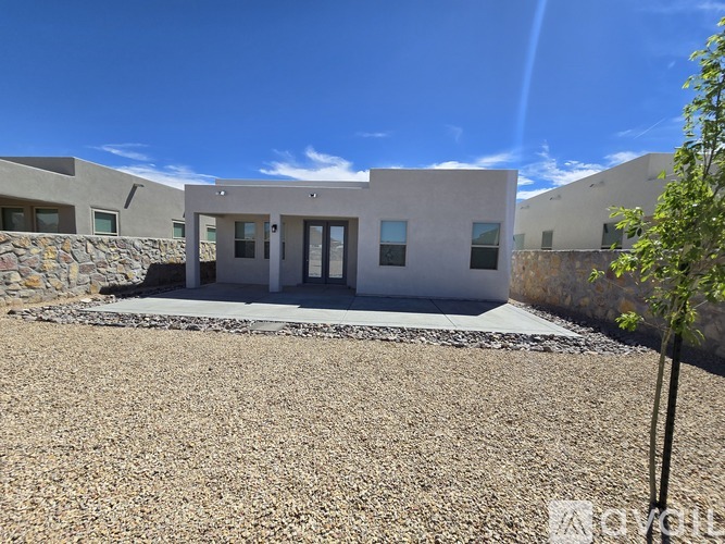 A modern building with a gravel driveway in front.