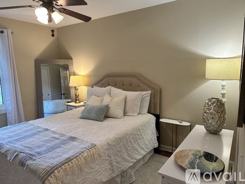 A bedroom with a large bed and a ceiling fan.