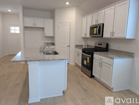 A kitchen with white cabinets and a granite countertop.
