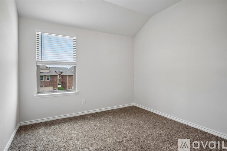 A room with a window showing a building outside.