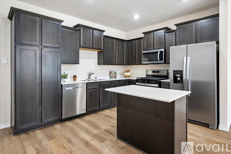A kitchen with dark wood cabinets and stainless steel appliances.