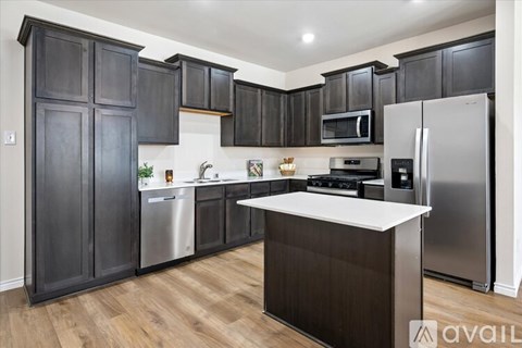 A kitchen with dark wood cabinets and stainless steel appliances.