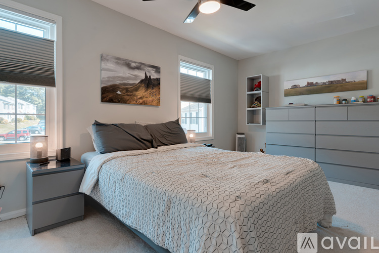 A bedroom with a large bed and two pictures on the wall.