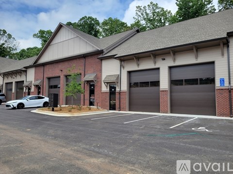 A parking lot with a car parked in front of a building with a sign that says "AVAILABLE".