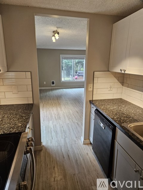 A kitchen with granite countertops and wooden cabinets.