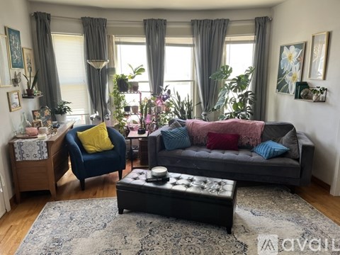 A living room with a blue armchair, a grey sofa, and a coffee table in the center.