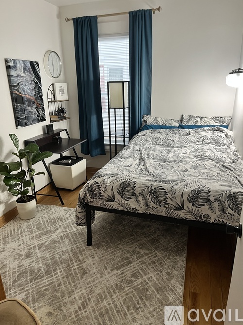 A bedroom with a large bed and a desk with a chair.