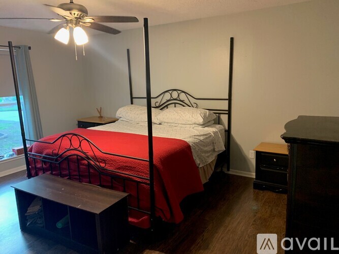 A bedroom with a four poster bed and a ceiling fan.