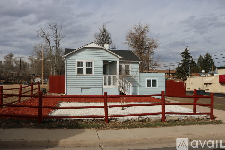A blue house with a red fence in front.
