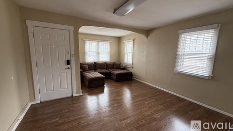 A room with a white door and a brown couch.