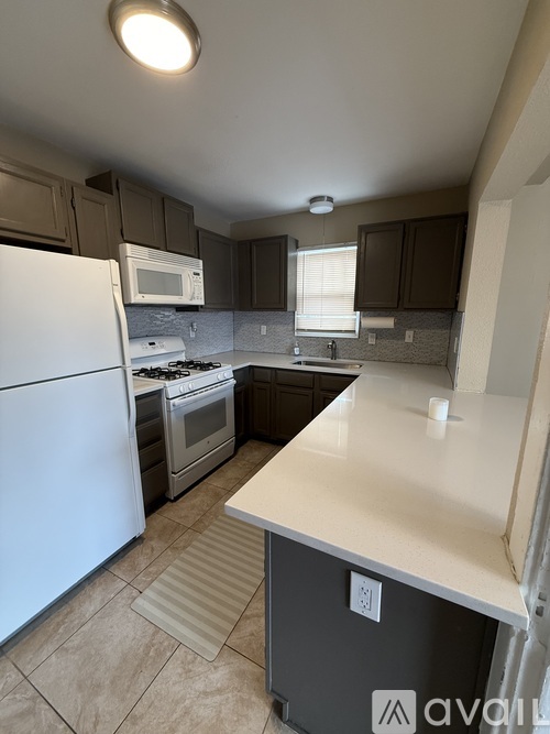 A kitchen with a white refrigerator and a white countertop.