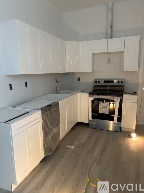 A kitchen with white cabinets and a stove top oven.