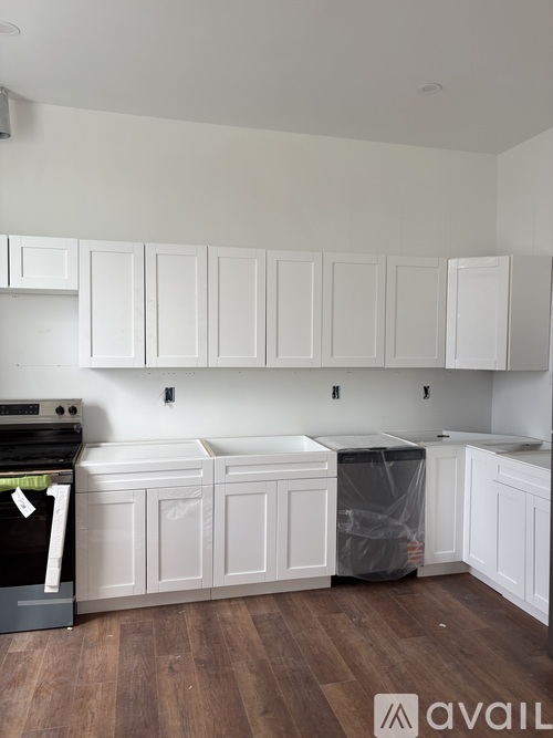 A kitchen with white cabinets and a black dishwasher.