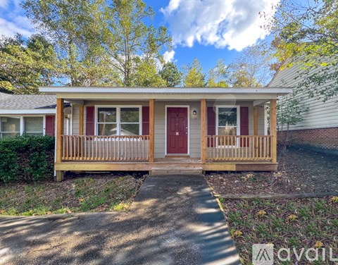 A small house with a red door and a wooden porch.