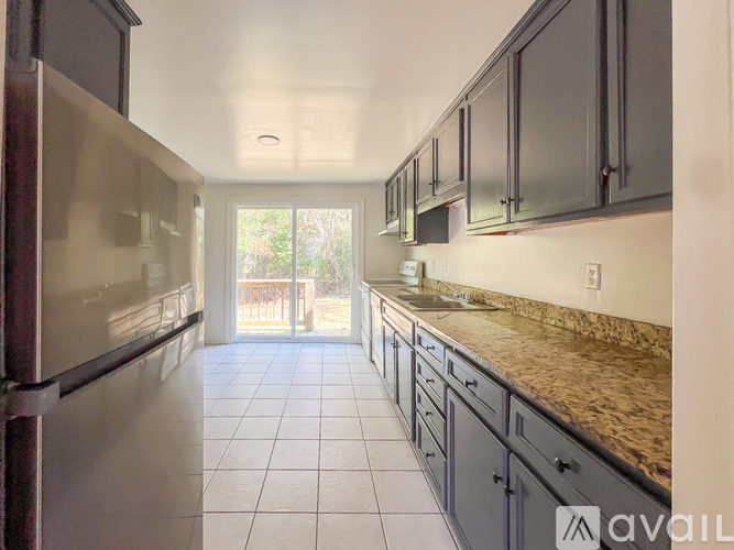 A kitchen with a refrigerator, cabinets, and a countertop.