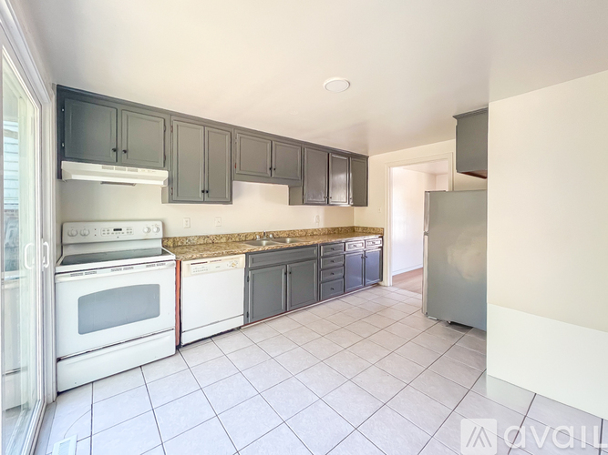 A kitchen with white appliances and grey cabinets.